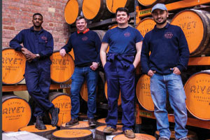 The Dockyard Gin distillery staff stood infront of barrels